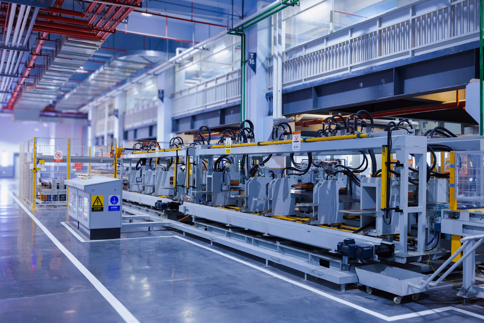 Interior of a modern manufacturing facility with an automated assembly line and industrial machinery.